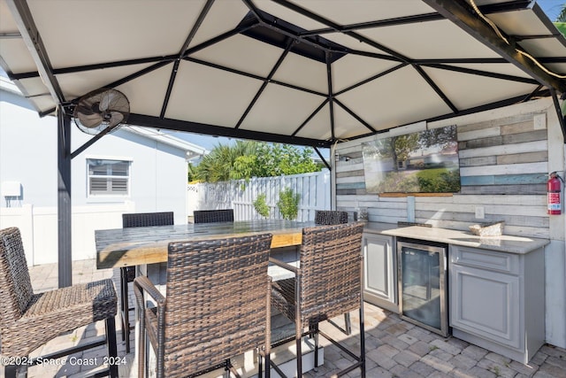 view of patio with wine cooler, an outdoor kitchen, and a bar