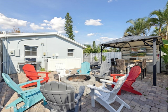 view of patio / terrace featuring a bar, a gazebo, grilling area, and an outdoor fire pit