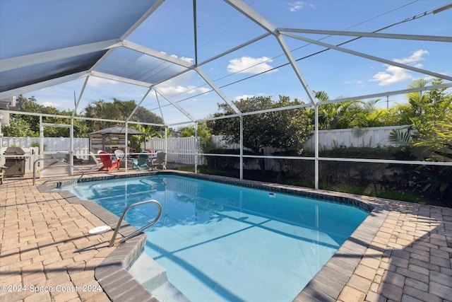 view of swimming pool featuring a storage shed, a lanai, and a patio area