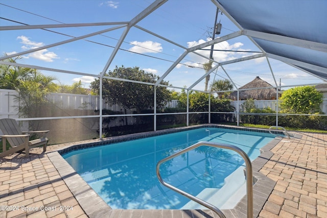 view of swimming pool with a patio and a lanai