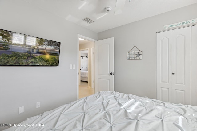 bedroom with ceiling fan and a closet