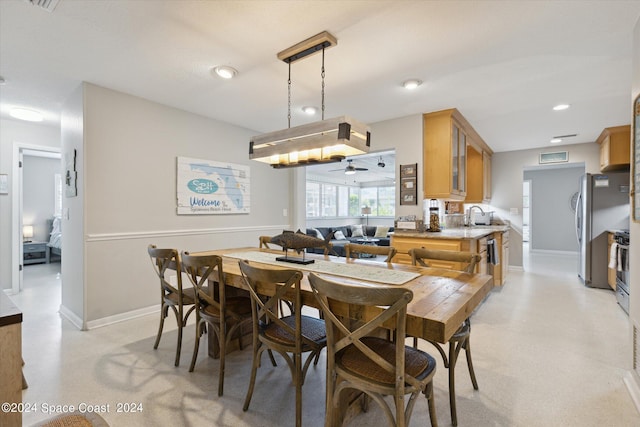 dining space with ceiling fan and sink