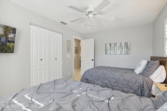 carpeted bedroom with ceiling fan and a closet