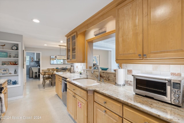 kitchen featuring hanging light fixtures, sink, tasteful backsplash, dishwasher, and light stone countertops