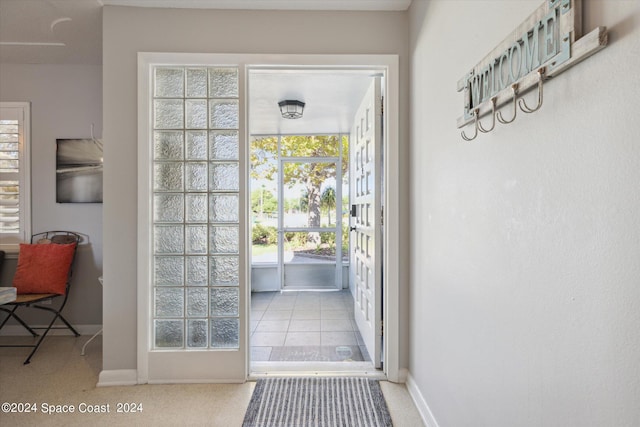 doorway to outside featuring light colored carpet and plenty of natural light