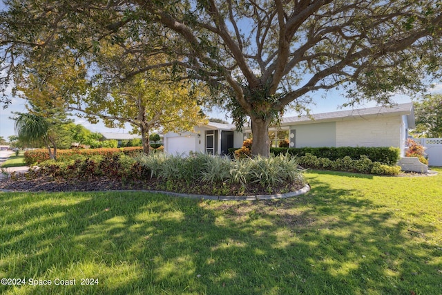 view of front of property with a garage and a front lawn