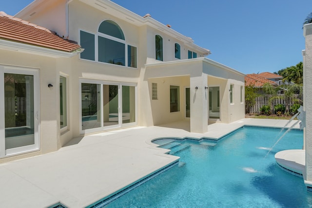 back of house featuring a patio area, a fenced in pool, and pool water feature