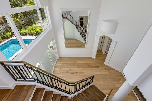 staircase with a high ceiling and hardwood / wood-style floors