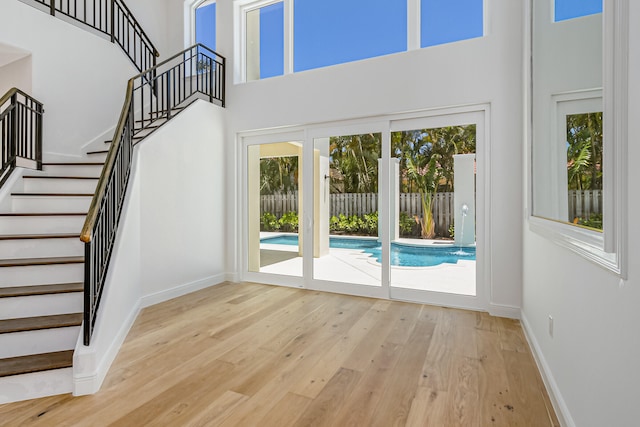 interior space featuring light wood-type flooring and a high ceiling