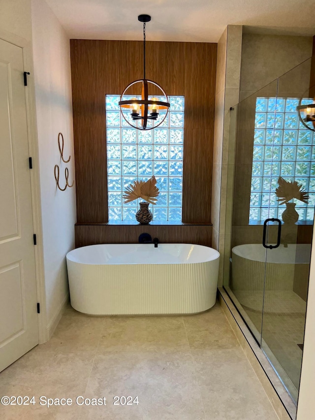 bathroom featuring independent shower and bath, an inviting chandelier, and a wealth of natural light