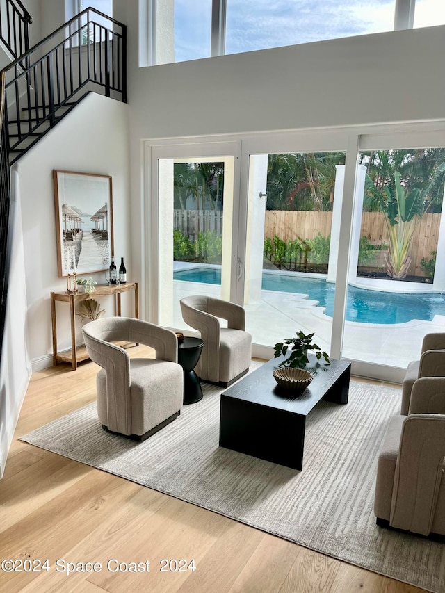 living room featuring a high ceiling and light hardwood / wood-style flooring