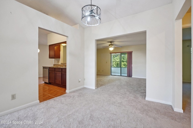 carpeted spare room with ceiling fan with notable chandelier and sink