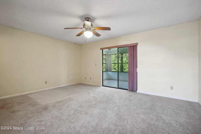 spare room featuring ceiling fan, carpet flooring, and a textured ceiling