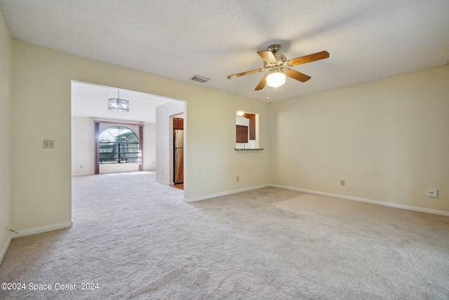 carpeted spare room featuring ceiling fan and a textured ceiling