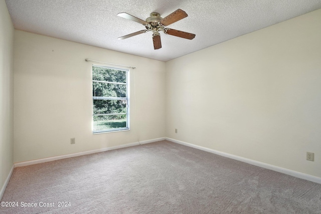 spare room featuring ceiling fan, a textured ceiling, and carpet