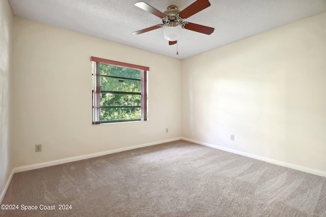 carpeted spare room with ceiling fan and a textured ceiling