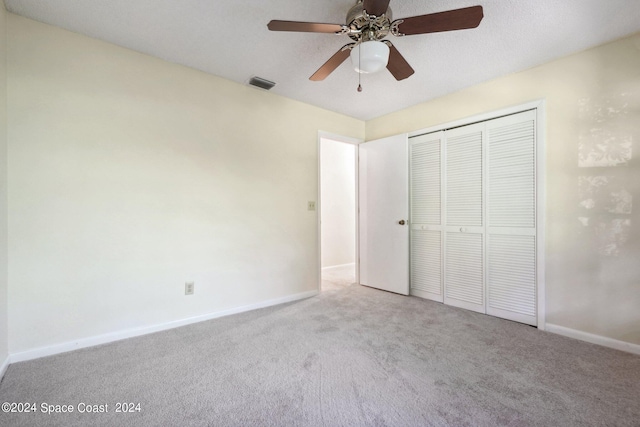 unfurnished bedroom with ceiling fan, light colored carpet, and a closet