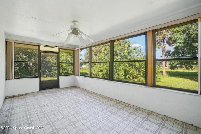 unfurnished sunroom with ceiling fan