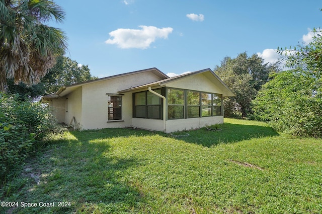 view of side of home featuring a yard and a sunroom