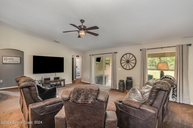 living room with ceiling fan, a textured ceiling, lofted ceiling, and carpet