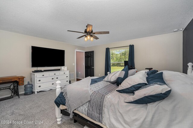 bedroom featuring ceiling fan, light colored carpet, and a textured ceiling