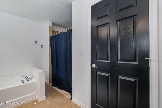 bathroom featuring independent shower and bath, a textured ceiling, and tile patterned flooring