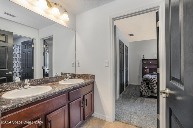 bathroom with vanity, a textured ceiling, and tile patterned floors