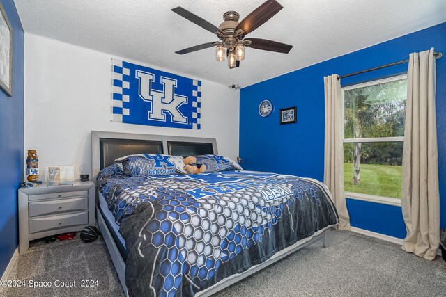 bedroom featuring ceiling fan, carpet floors, and a textured ceiling