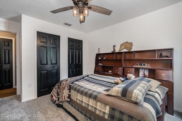 bedroom with a closet, carpet, ceiling fan, and a textured ceiling