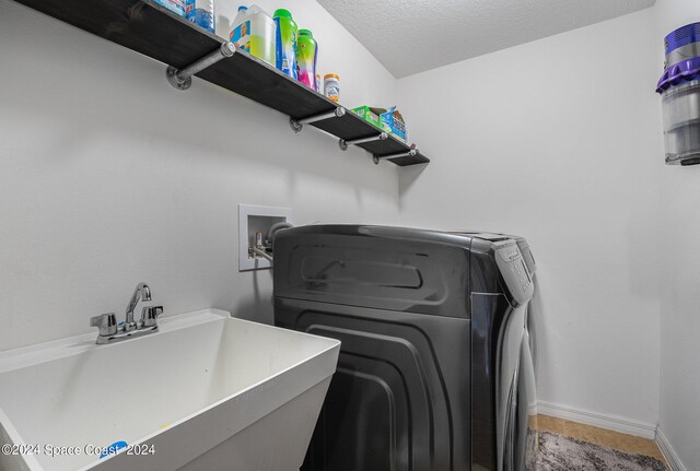 laundry room featuring hookup for a washing machine, a textured ceiling, and sink