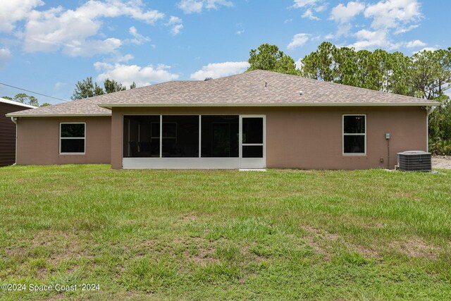 rear view of property featuring a yard, a sunroom, and central AC