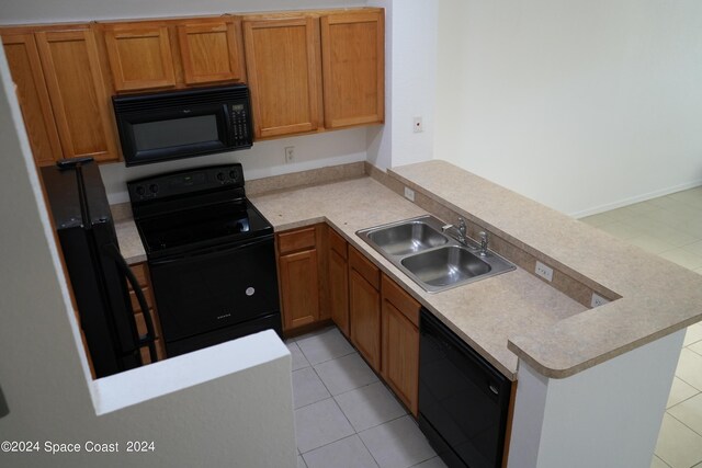 kitchen featuring light tile patterned floors, sink, kitchen peninsula, and black appliances