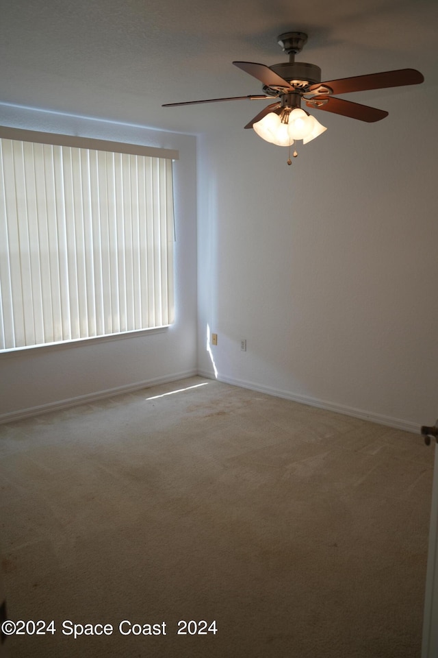 spare room featuring ceiling fan and carpet floors