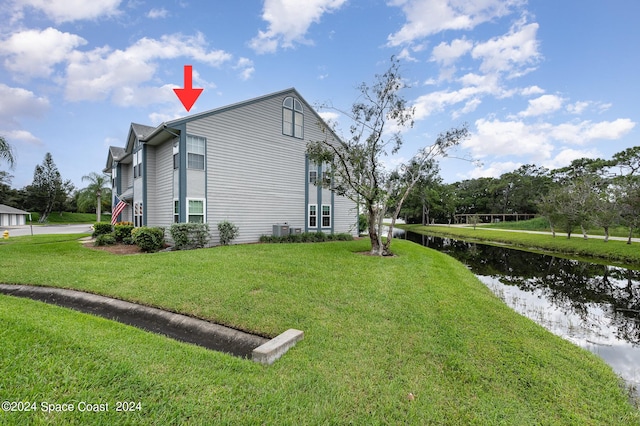 view of side of home featuring central AC unit and a yard