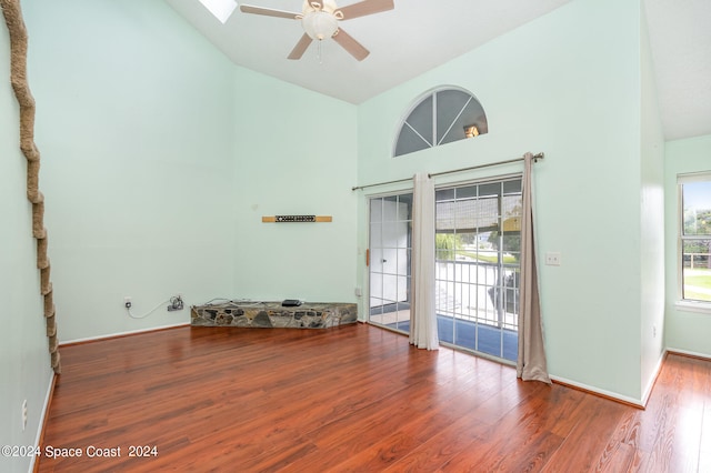 empty room featuring high vaulted ceiling, ceiling fan, and hardwood / wood-style flooring