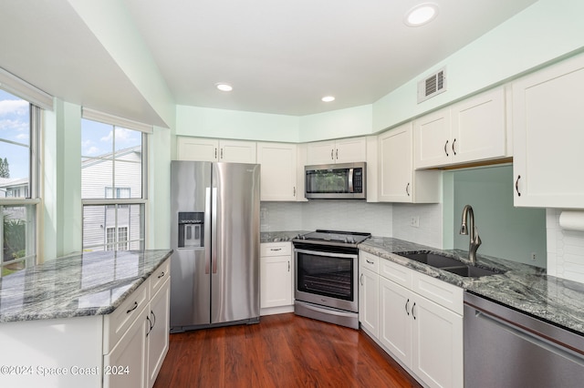 kitchen with appliances with stainless steel finishes, dark hardwood / wood-style floors, sink, and white cabinetry