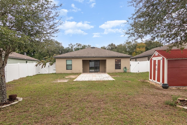 back of house featuring a patio, a yard, and a storage unit