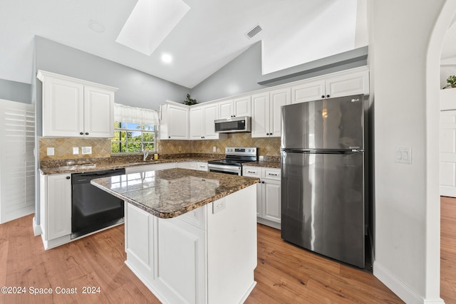 kitchen with white cabinetry, a skylight, appliances with stainless steel finishes, and a center island