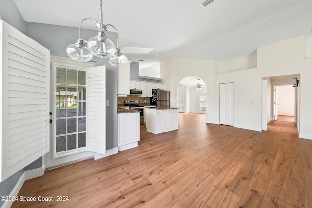 kitchen with appliances with stainless steel finishes, white cabinetry, backsplash, pendant lighting, and light wood-type flooring