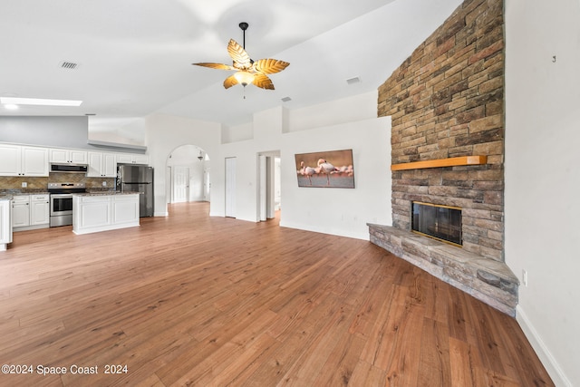 unfurnished living room featuring high vaulted ceiling, light hardwood / wood-style floors, ceiling fan, and a fireplace