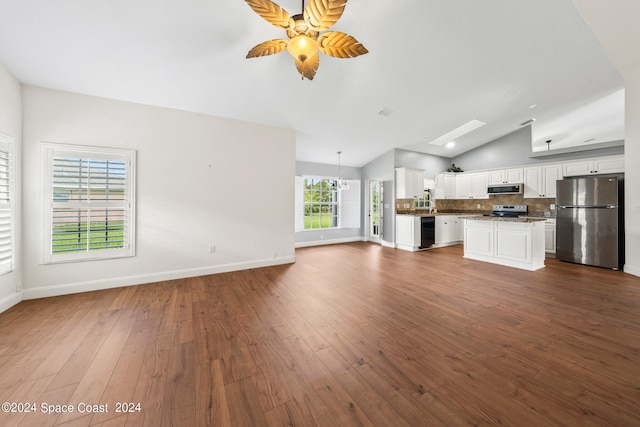 unfurnished living room with ceiling fan, dark hardwood / wood-style floors, and lofted ceiling with skylight