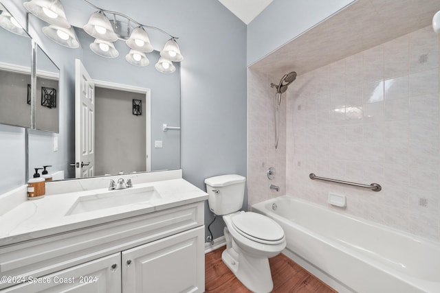 full bathroom with tiled shower / bath combo, hardwood / wood-style floors, toilet, and vanity