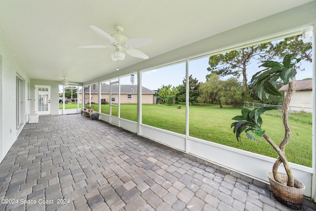 unfurnished sunroom featuring ceiling fan