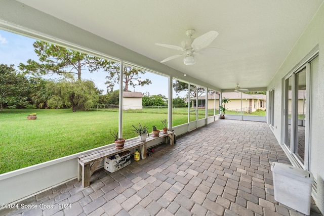 unfurnished sunroom featuring a healthy amount of sunlight and ceiling fan