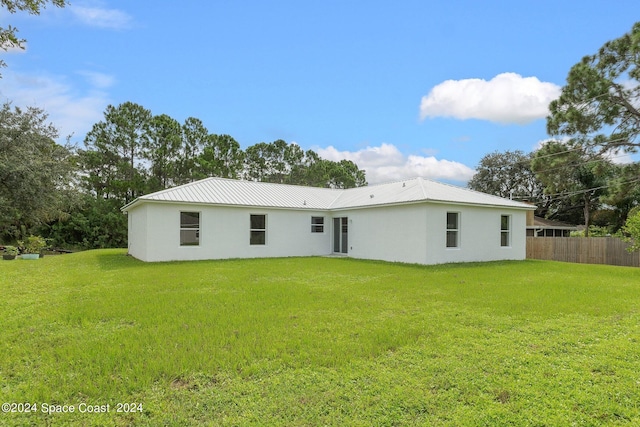 rear view of property featuring a yard