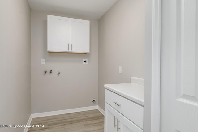 clothes washing area featuring washer hookup, cabinets, light hardwood / wood-style flooring, and electric dryer hookup