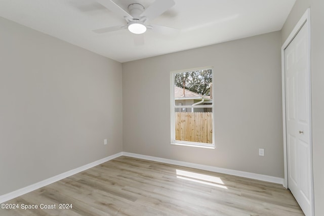 unfurnished bedroom featuring light hardwood / wood-style floors, ceiling fan, and a closet