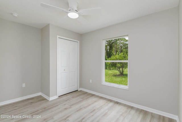 unfurnished bedroom featuring light hardwood / wood-style floors, a closet, and ceiling fan