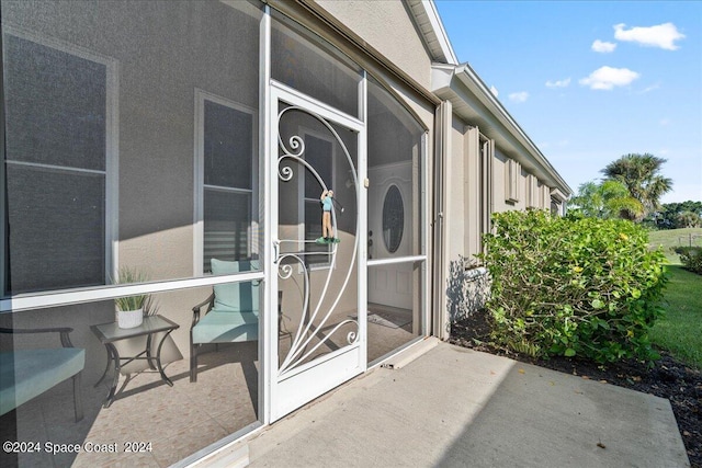 view of exterior entry with a patio area