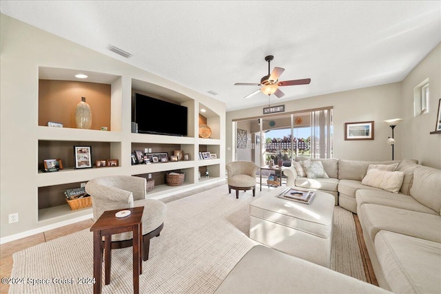 living room featuring a textured ceiling, light tile patterned flooring, ceiling fan, and built in features